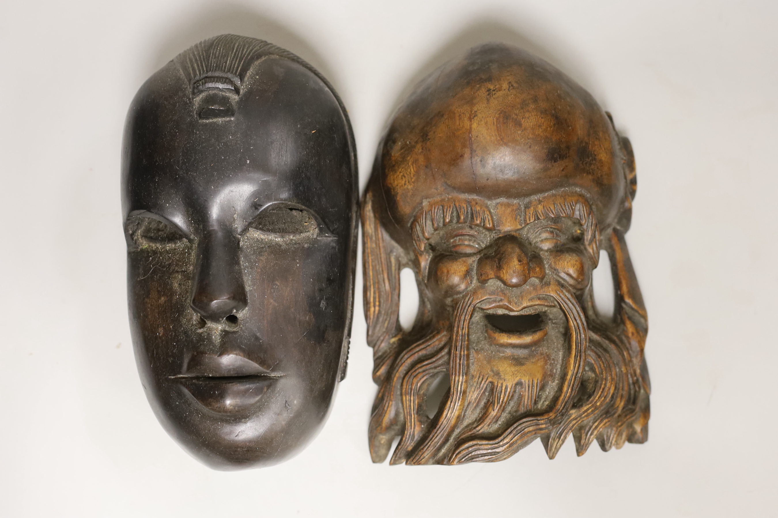 A Chinese Shou Lao wooden mask and an African mask, 26.5cm high